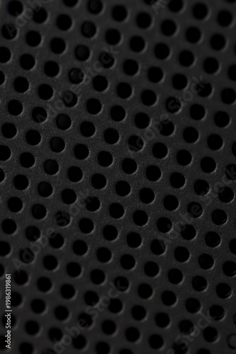 a plastic grate from a household appliance to provide a cooling system and air circulation, a large number of holes in a plastic black panel
