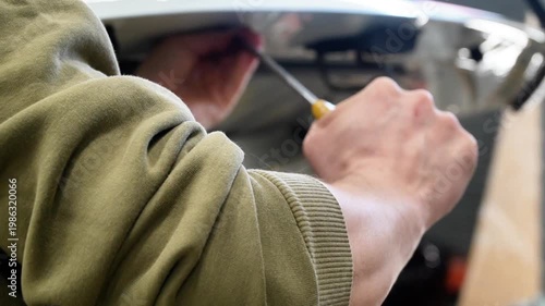 Body repair. A specialist repairs a dent on the car body without painting. Paintless Car Dent Repair. PDR. Process of paintless dent repair on car body. The mechanic at the auto shop with tools. 
