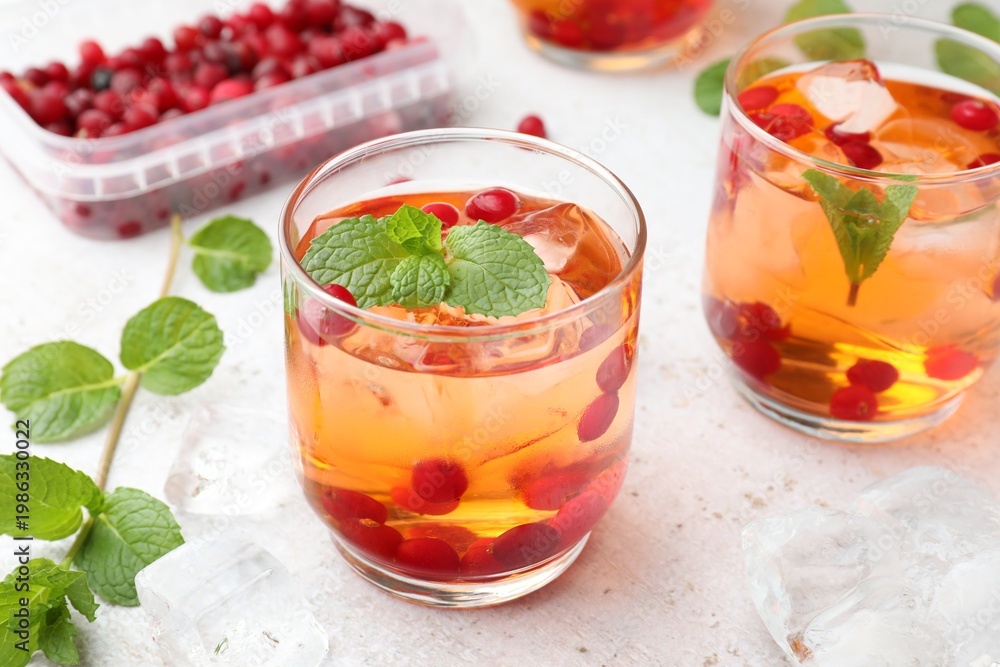 Fototapeta premium Refreshing cocktails with cranberries and mint on light table, closeup