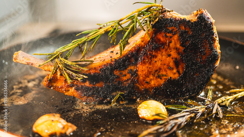 Photography Pork cutlet searing in a pan with garlic and rosemary, steam rising