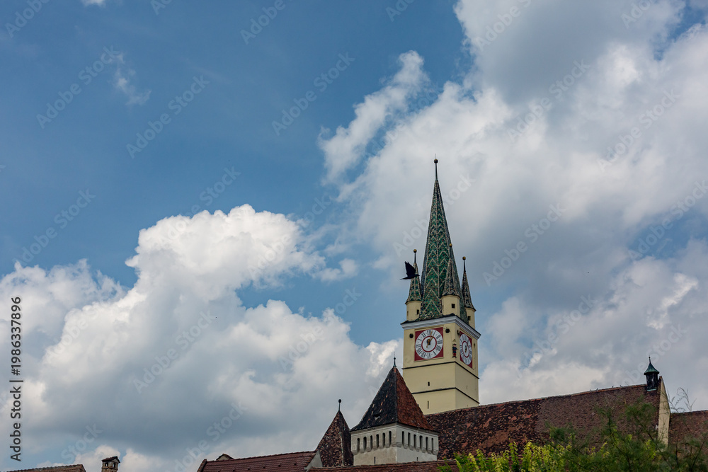 Obraz premium beneath the open sky across Soala, Romania, clock tower on the top of a building, bird flying by