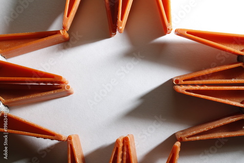 Foto Conjunto de broches de ropa en composición circular sobre fondo blanco con espacio para texto, plásticos de color naranja en composición circular sobre fondo blanco limpio con sombras suaves
