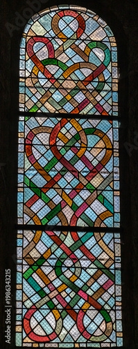 Cornil (Corrèze, Nouvelle aquitaine, France) - Détail de vitrail avec entrelacs colorés de l'église Saint-Etienne
