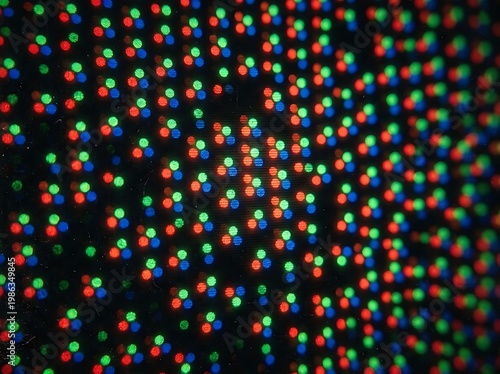 IA generated, extreme macro photography of a digital screen display showing a vibrant grid of RGB pixels and sub-pixels creating a technical textured pattern with multicolored light dots.
