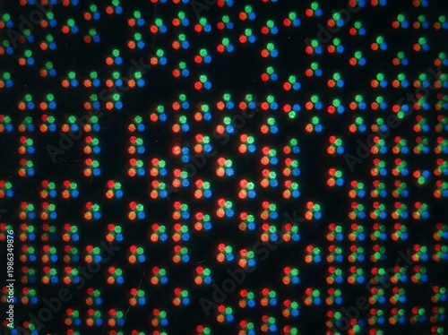 IA generated, extreme macro photography of a digital screen display showing a vibrant grid of RGB pixels and sub-pixels creating a technical textured pattern with multicolored light dots.