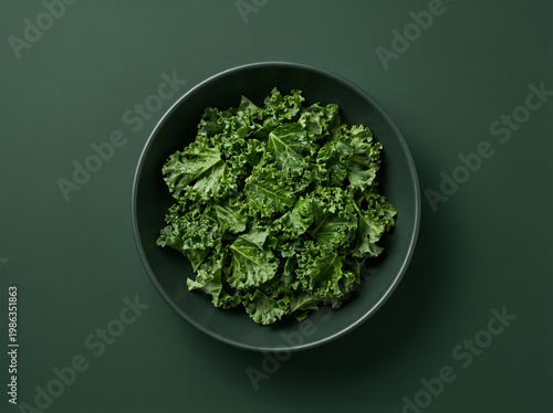 Photos Top view of fresh chopped kale in a dark bowl on a dark green background