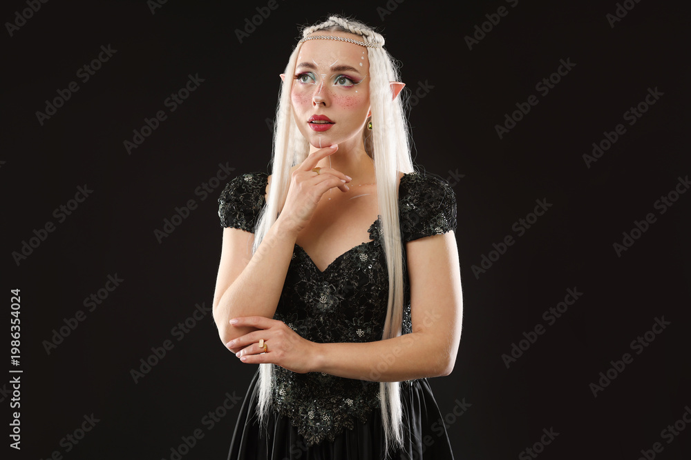 Fototapeta premium Beautiful girl dressed as elf on black background