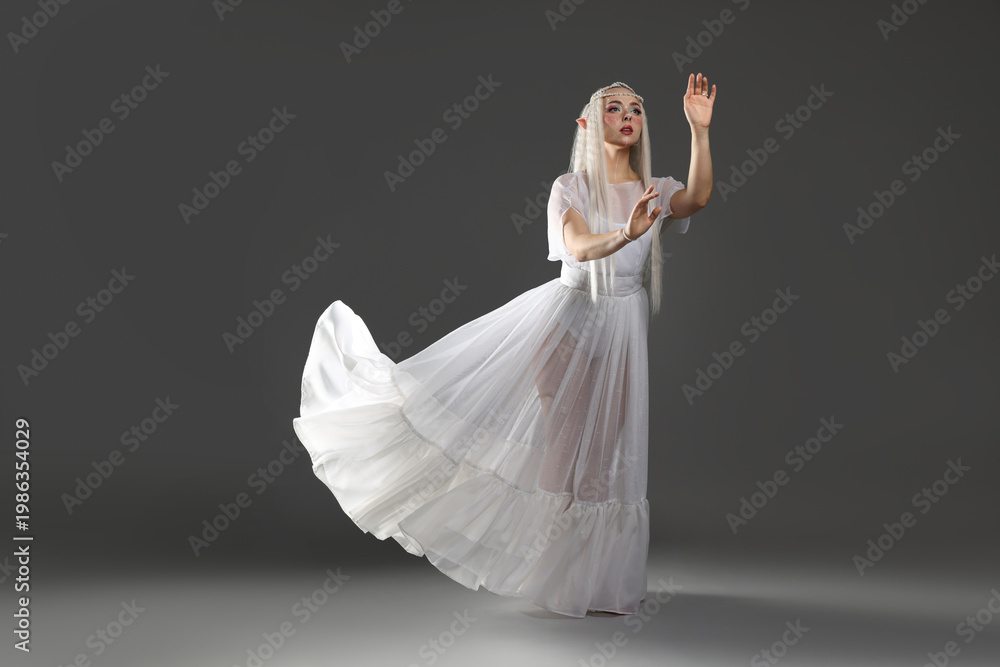 Fototapeta premium Beautiful girl dressed as elf on grey background