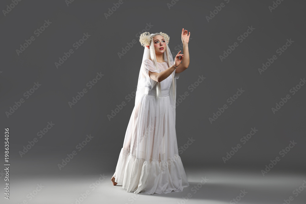 Naklejka premium Beautiful girl dressed as elf on grey background