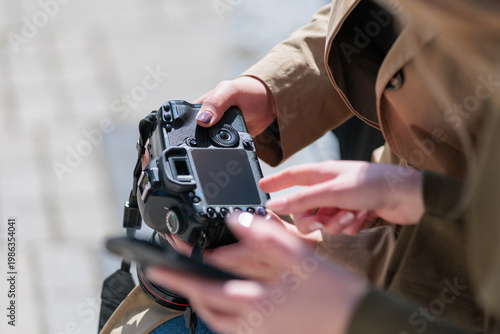 Close up of photographer and model hands holding digital camera