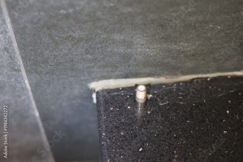 Close-up of a silver coaxial cable connector lying on a textured surface