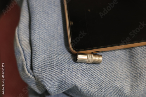 Close-up of a silver coaxial cable connector lying on a textured surface