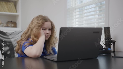 Child studying quietly on laptop. School kid study online. Child focused during laptop learning. Child typing answers on laptop. Child learning remotely online.