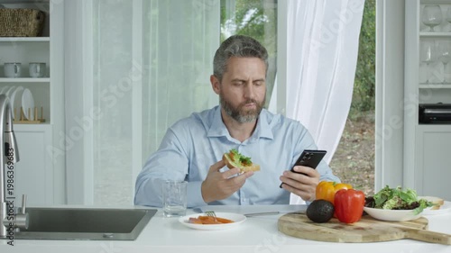 Morning kitchen lifestyle with a man preparing fresh breakfast. Man focused on nutrition during morning kitchen routine. Kitchen morning concept showing a man and healthy homemade meal.