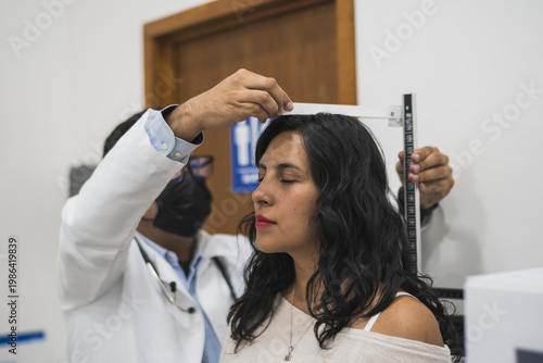 Foto Doctor measuring a female patient's height on a scale