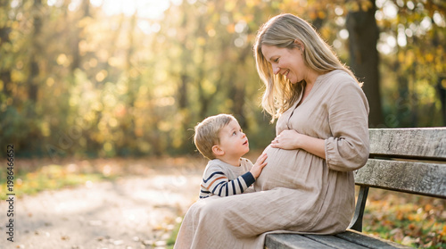 Mother's Day expectant mother with toddler son on park bench showing sibling anticipation connection for lifestyle magazine editorial content