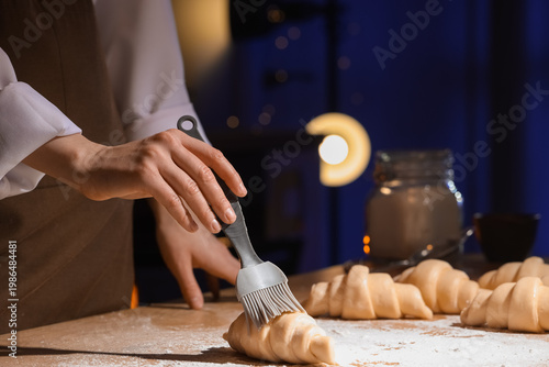 Female baker greasing raw c...