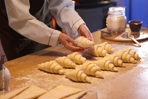 Female baker making croissa...