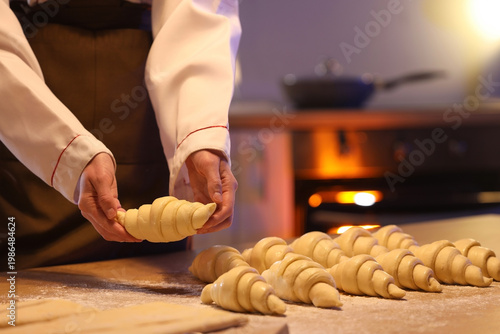Female baker making croissa...