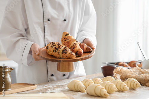 Female baker holding wooden...