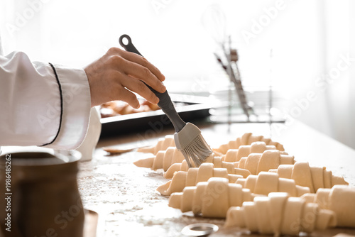 Female baker's hand greasin...