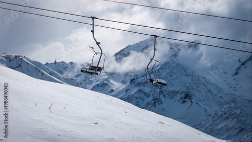 Obraz na płótnie Ski lift over snowy mountain slope with dramatic clouds in Andes winter landscape Argentina