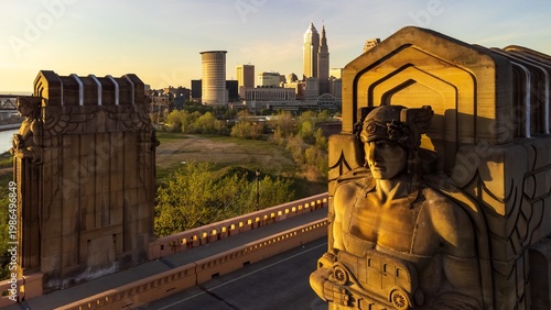Art deco statue at sunset with city skyline in the distance - Cleveland, Ohio