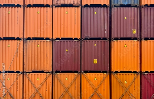 Close-up view of stacked shipping containers forming a colorful industrial pattern, representing global logistics, cargo transportation, trade industry, and maritime shipping infrastructure
