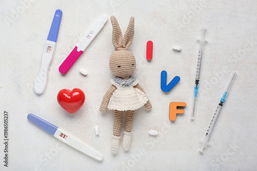 Positive pregnancy tests with crochet bunny toy, syringes, pills and heart on...