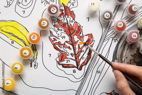 Woman paints on canvas for ...