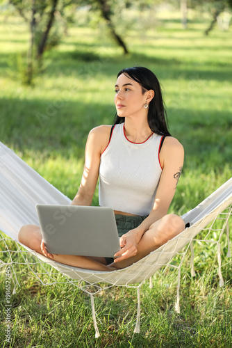 Young woman using laptop in...