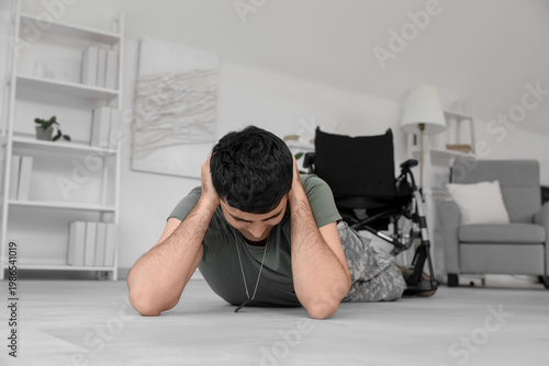 Young soldier with PTSD lying on floor at home