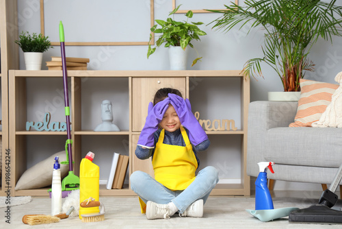 Quadro su tela Tired little girl with cleaning supplies at home
