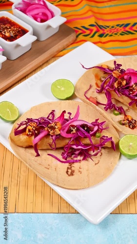 Baja California style seafood tacos on a bamboo mat background and side dishes