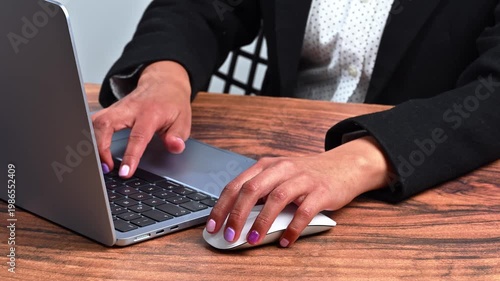 Businesswoman working in a modern office with a laptop and mouse