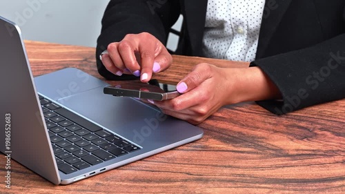Modern workspace with person using high-end smartphone and laptop