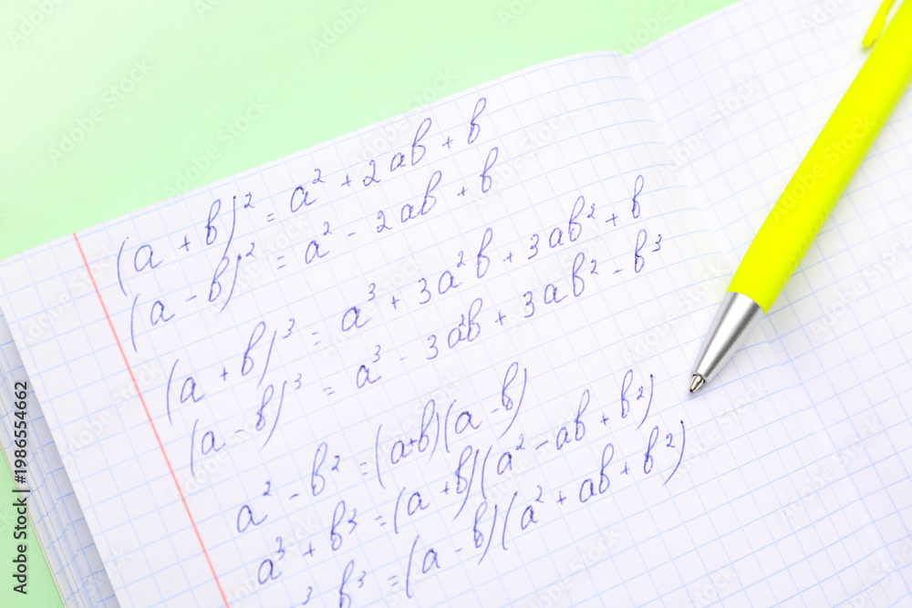 Fototapeta premium Copybook with maths formulas and pen on green background
