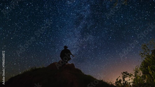 Man climbing a hill to watch the milky way night sky