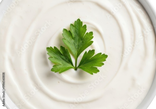 Fresh white sour cream with a green parsley leaf in a bowl