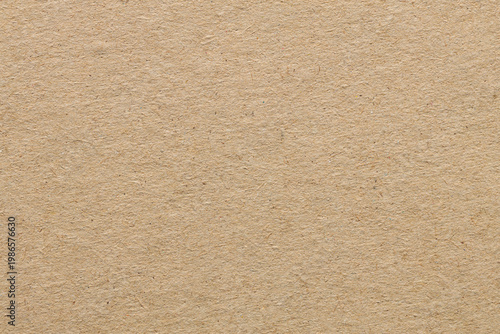 Rough beige cardboard paper texture background with natural fiber grain and copy space
