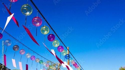Colorful Japanese Wind Chimes Furin Under Blue Summer Sky Background with Copy Space