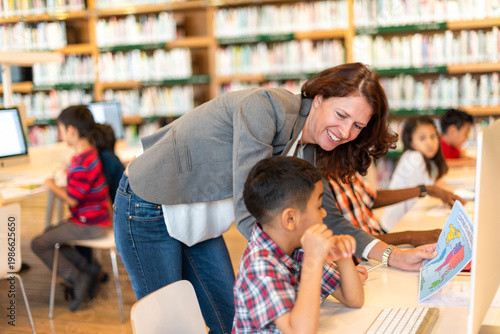 Foto Teacher guiding students in library.