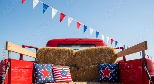 A red vintage truck decorated with hay, patriotic pillows, and flags for Happy 4th july celebrations in a rural setting.