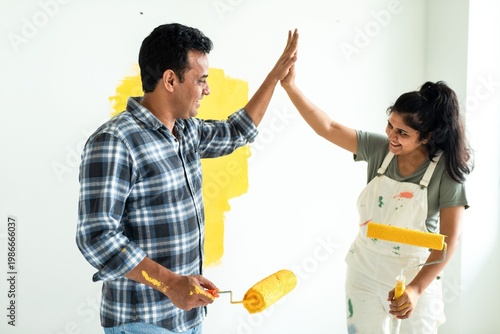 Photography Couple painting wall together joyfully