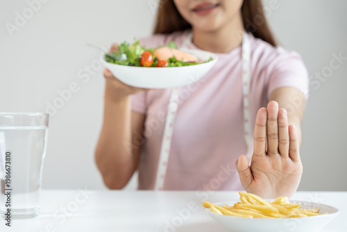 Beauty slim female body confuse French fries. Woman in restaurant achieves weight loss goal for healthy life, crazy about thinness, thin waist, nutritionist. Diet, body shape.
