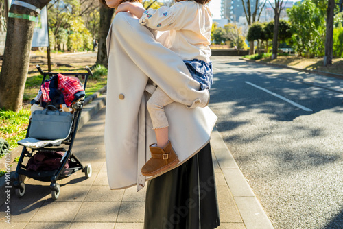Detail Shot of a Mother Carrying Her Daughter Piggyback During a Walk in the Park