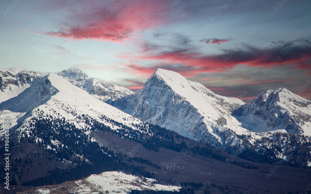Fototapeta premium a spectacular sunset over the snow-capped mountains
