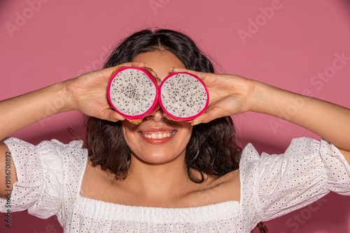 Foto Playful woman holding dragon fruit