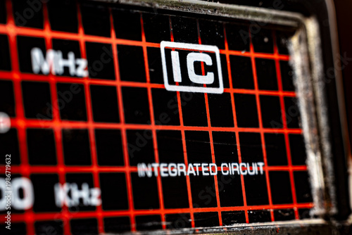 Extreme Macro of Vintage Analog Radio Frequency Display with Red Integrated Circuit Grid and MHz Kilocalorie Labels, Retro Electronic Technology Background for Engineering and Sound Design