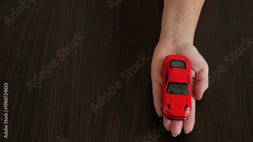 Zefir or marshmallows as pink rose and red car model in hand, Gift concept.